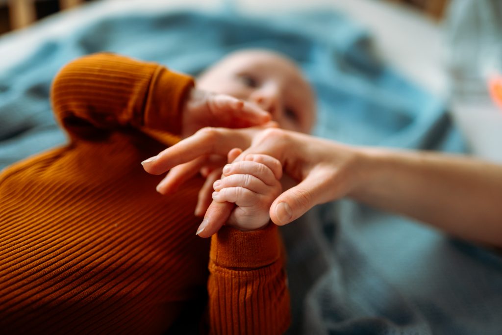 Baby toddler holding mother's hand