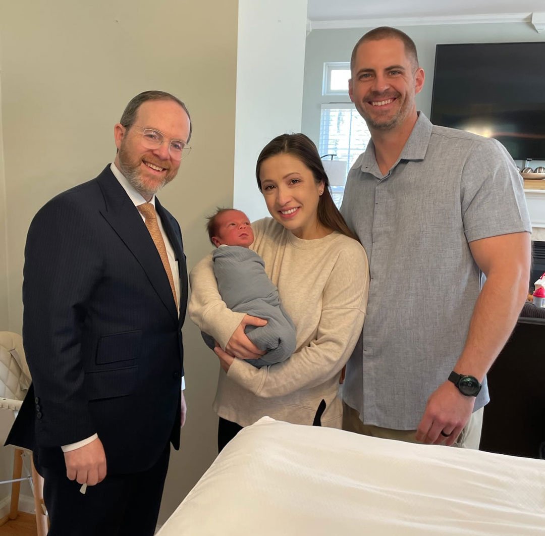 rabbi with new born and family
